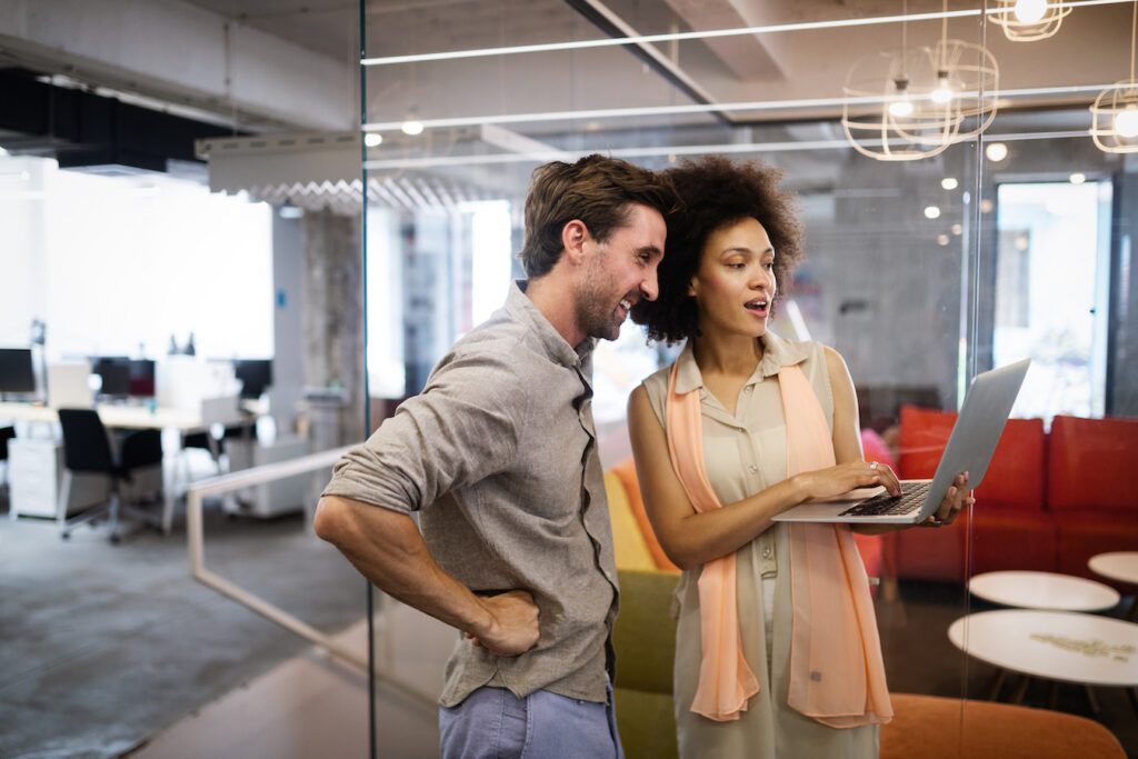 Two business people collaborating on project in modern office