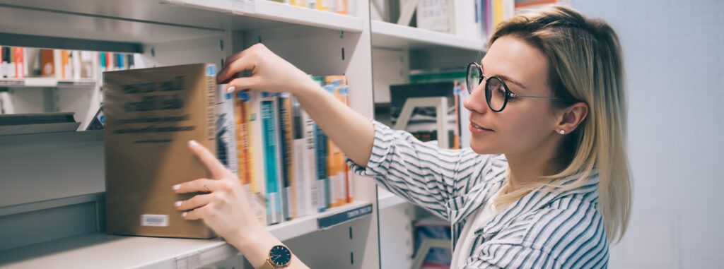 Woman putting books on a shelf