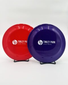 A red frisbee and a purple frisbee