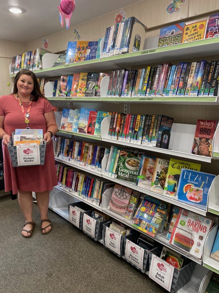 Library Staff member holding one of the "Yours to Keep" boxes in the bookmobile