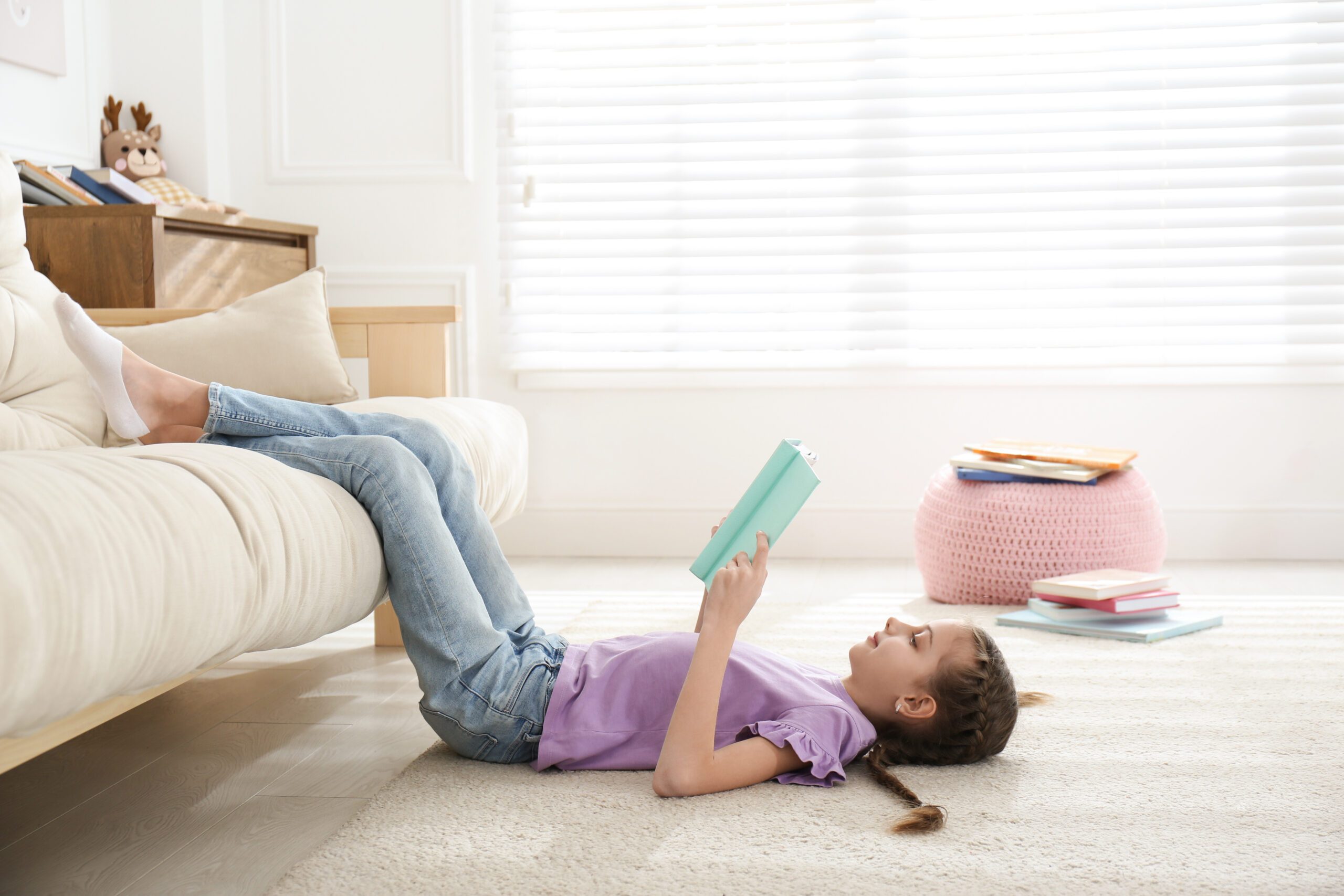 Tween girl reading at home.