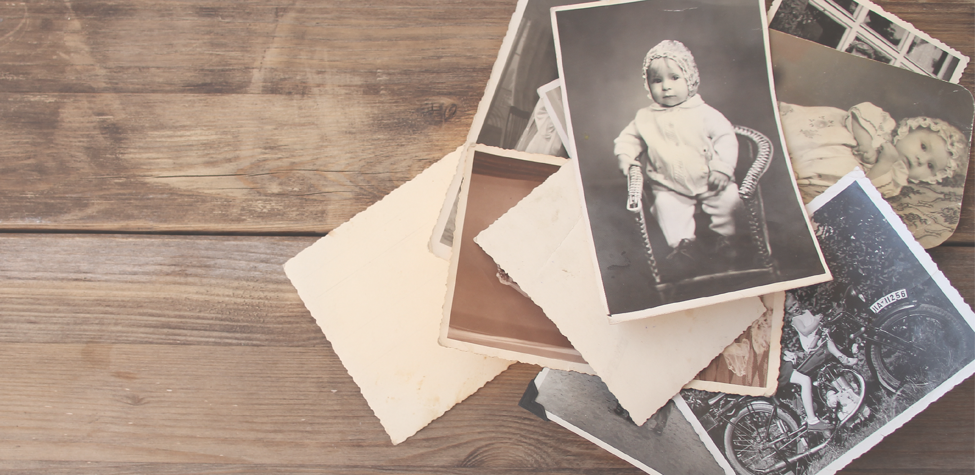 assorted old photographs on a wooden table