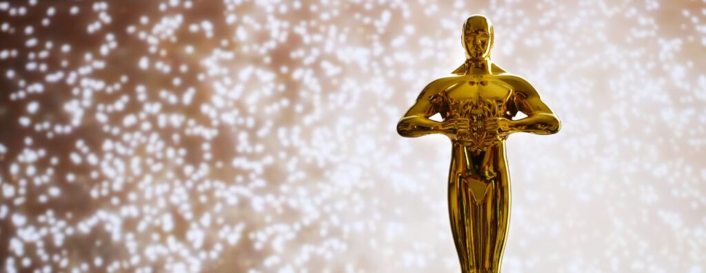 Hollywood Golden Oscar statue in front of sparkling lights