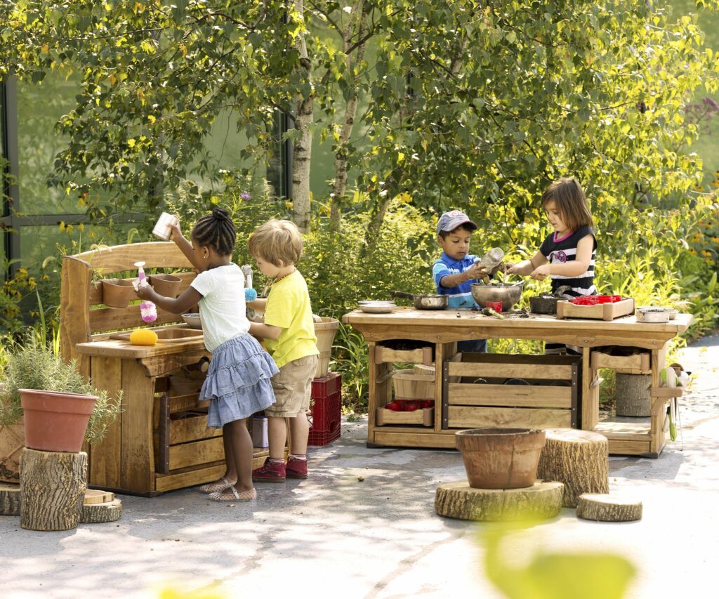 Product photograph of children playing with outdoor wooden kitchen set
