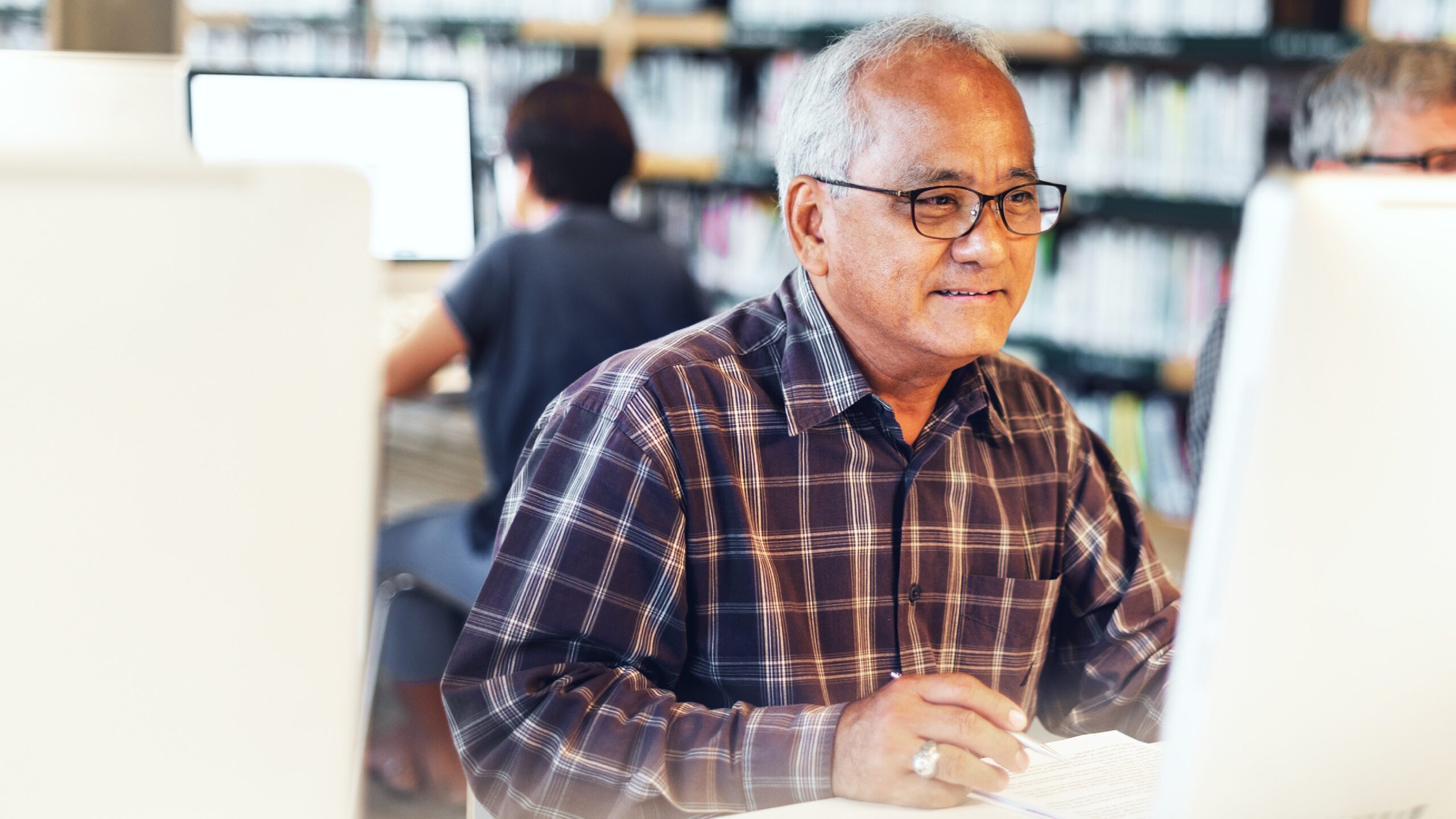 older man looking at a computer screen and smiling