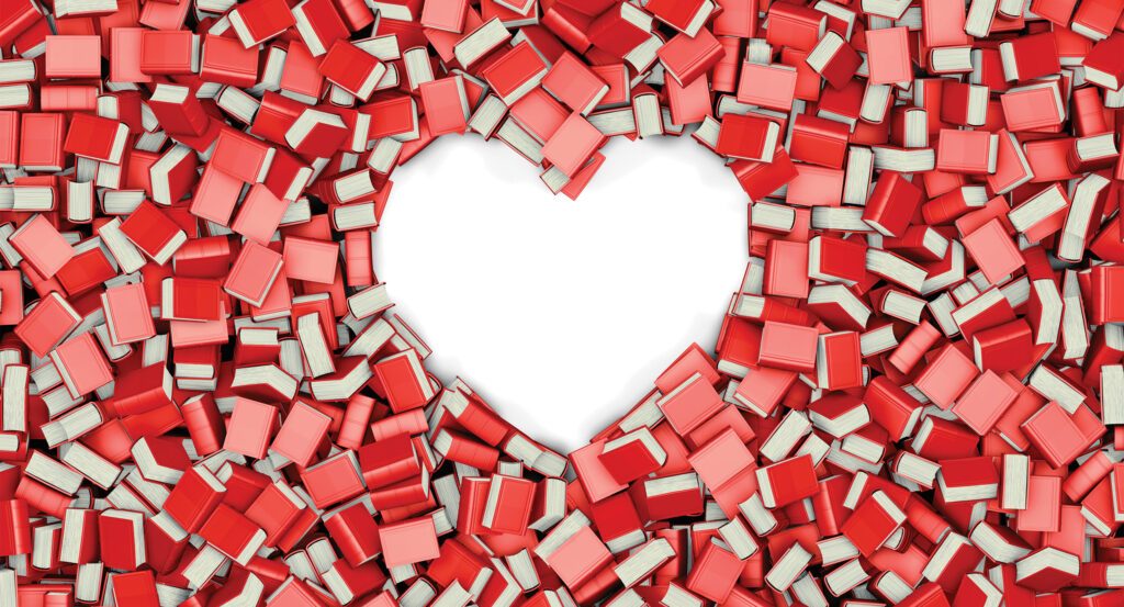 red and pink books scattered around, with a space shaped like a heart in the center