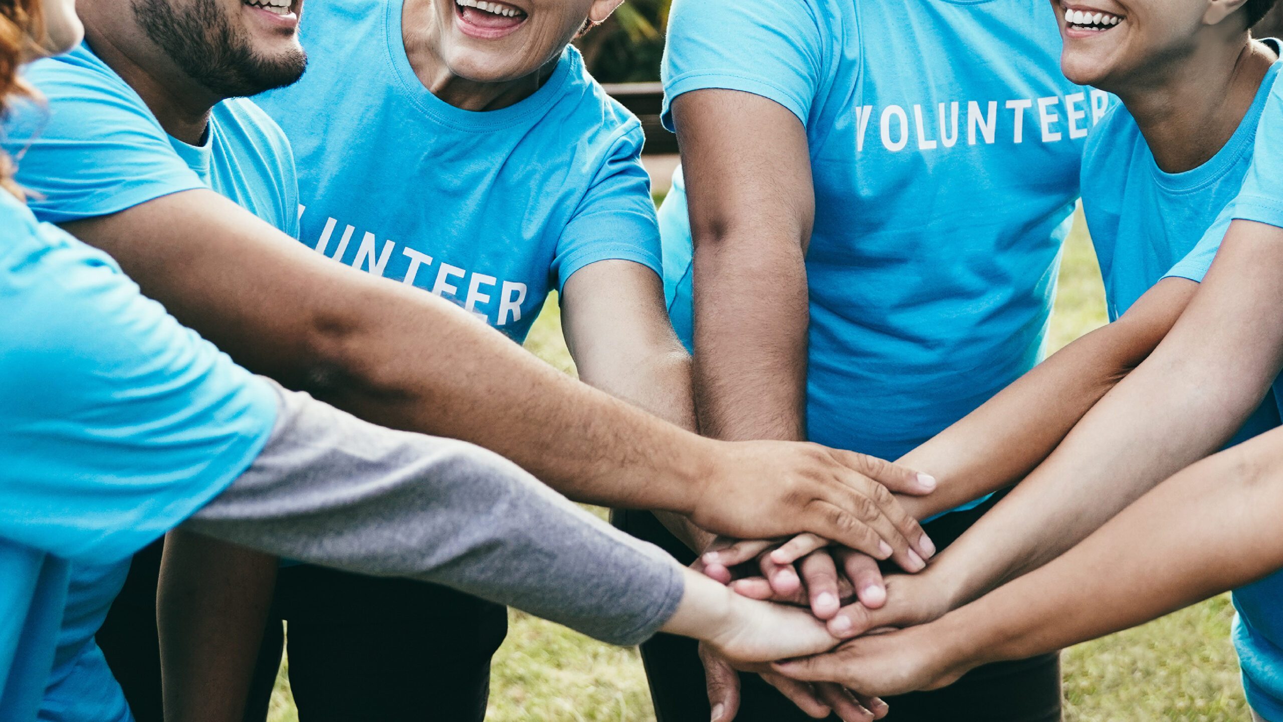 Group of volunteers in a circle putting their hands together
