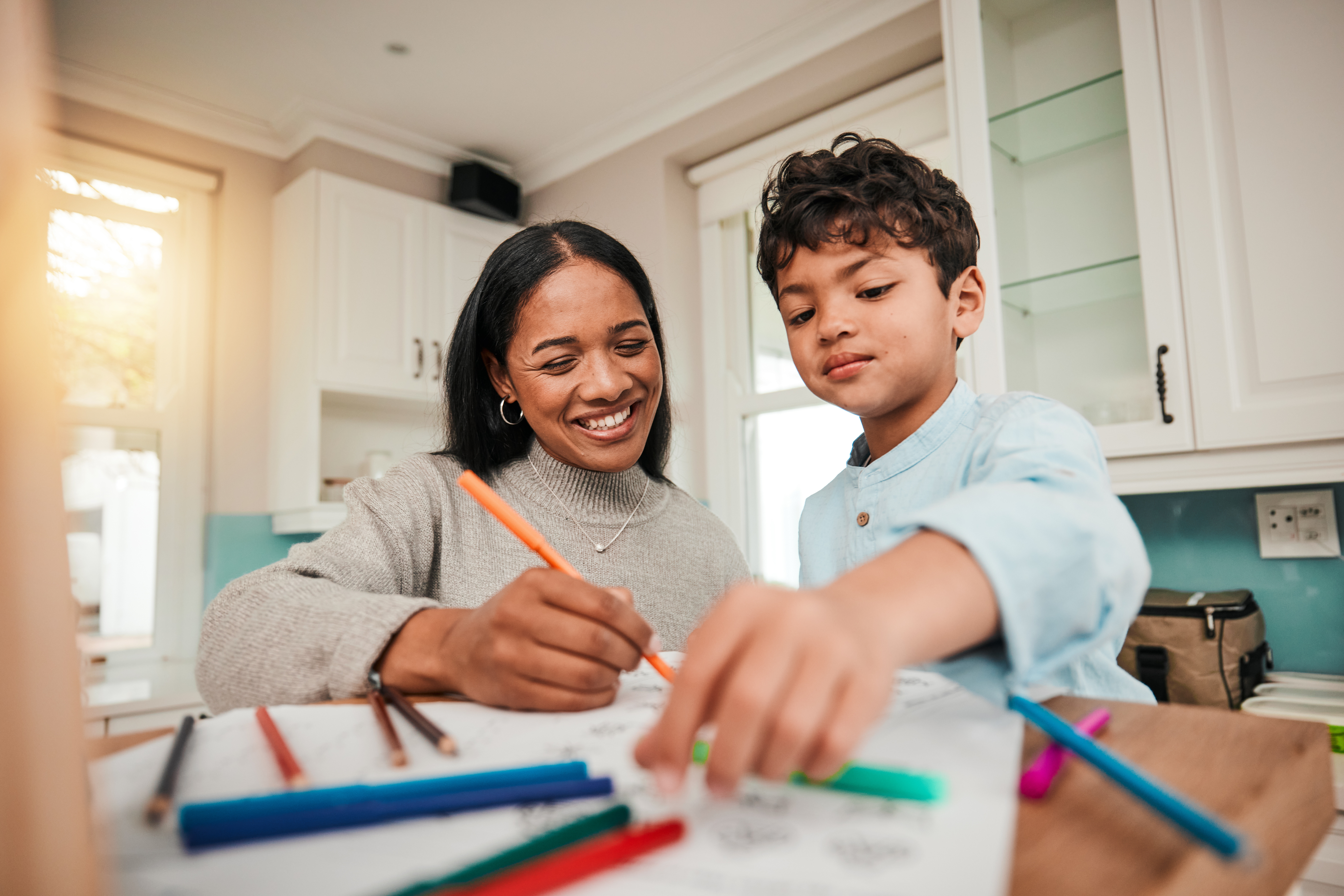 Mother and son completing a homeschool lesson in a kitchen