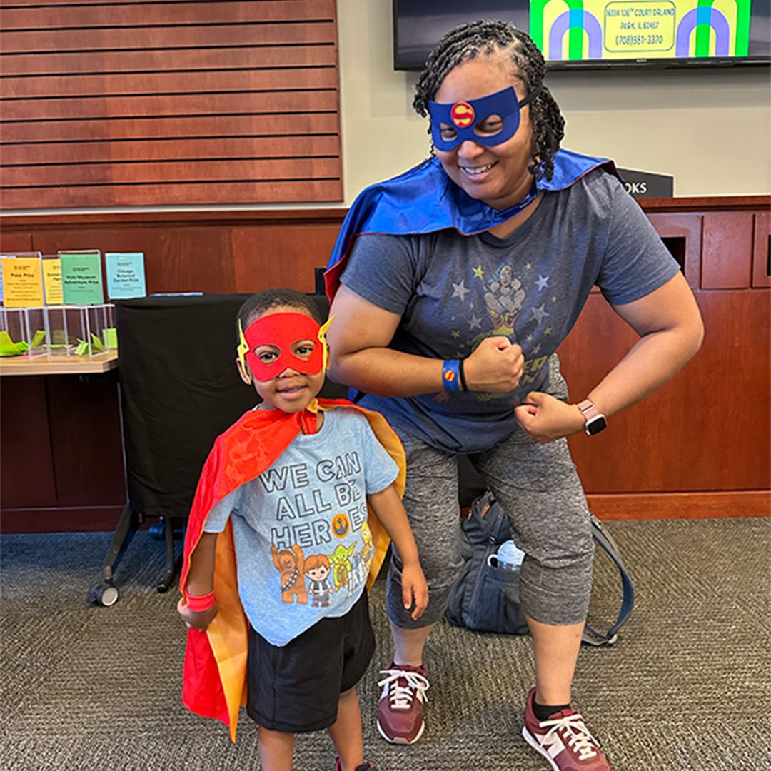 Mother and Son posing while dressed in superhero capes and masks
