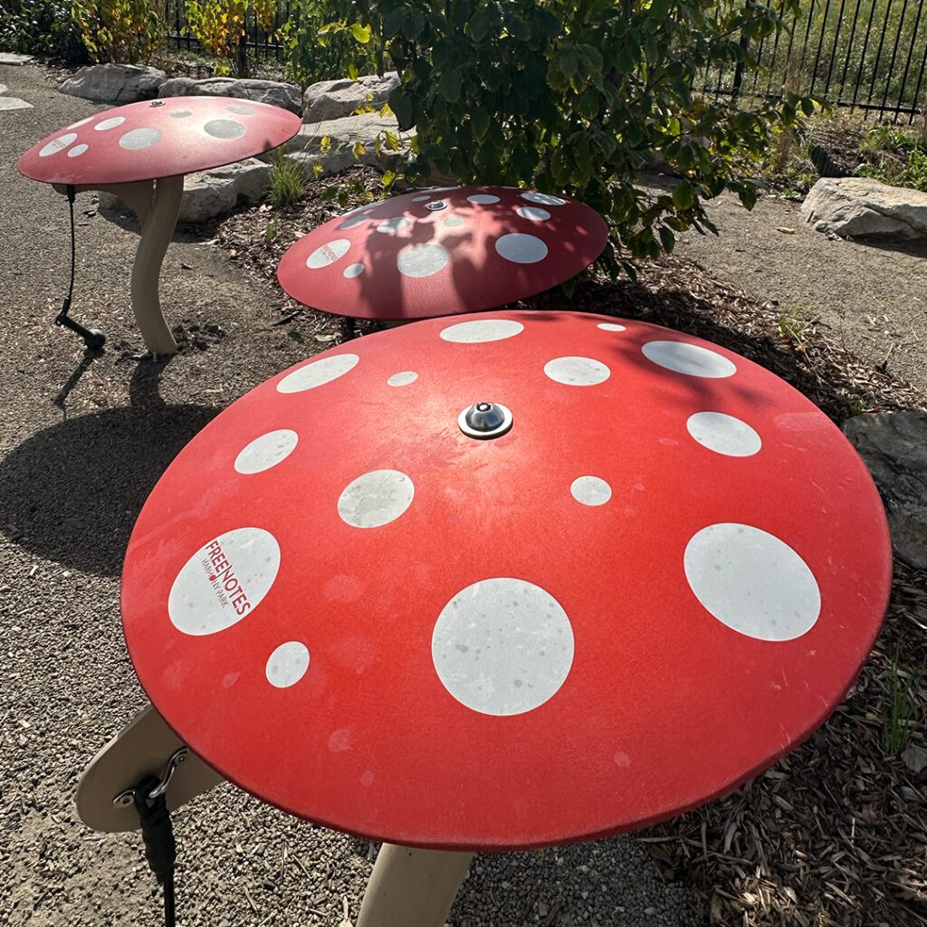 three musical play elements that look like red mushrooms with white spots